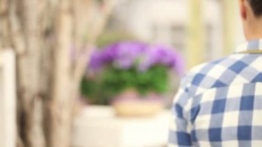 Bahçe bahar kavramı, mor campanula'lar beyaz hasır sepet çiçeklerle çalışma kadın çiçekçi