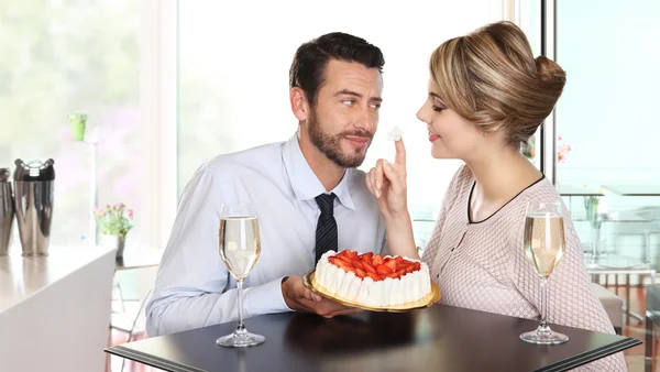 Šťastný pár v baru s šumivým vínem a dort, láska koncept — Stock fotografie