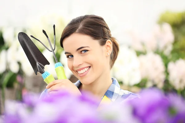 Mulher primavera sorrindo no jardim com ferramentas nas mãos — Fotografia de Stock