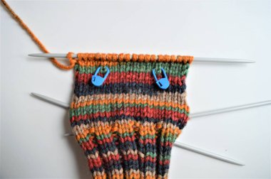 Renkli iplikten yapılmış yün bir çorap örme işlemi.