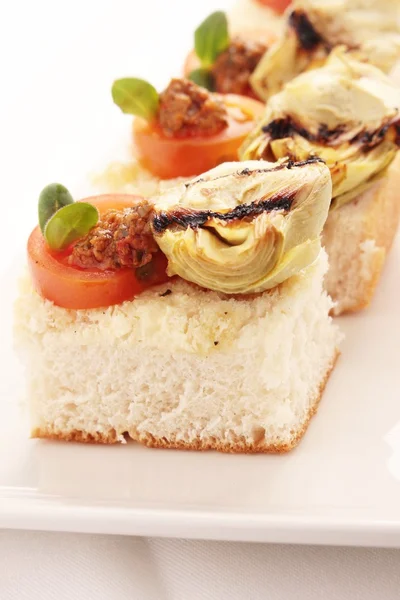 Artichokes and tomatoes canapes — Stock Photo, Image