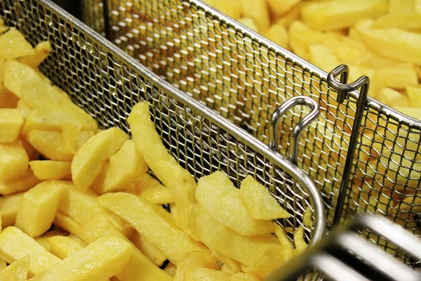 Deep frying chipped potatoes — Stock Photo, Image