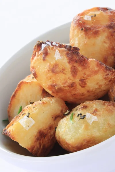 Roast potatoesin serving dish — Stock Photo, Image