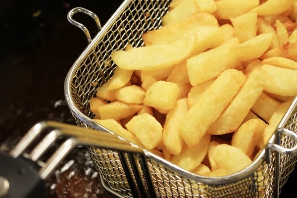 Deep frying chipped potatoes — Stock Photo, Image