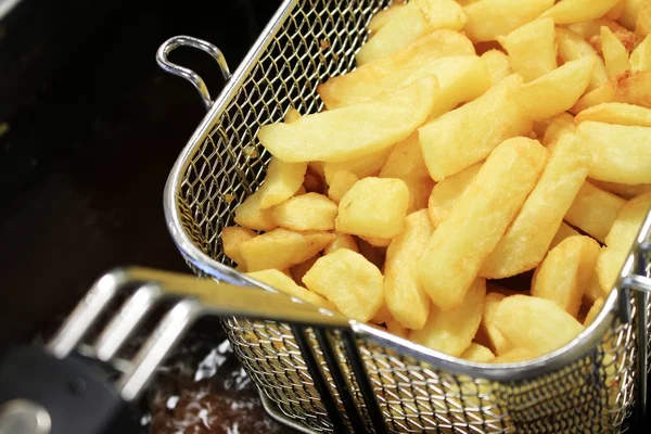 Deep frying chipped potatoes — Stock Photo, Image