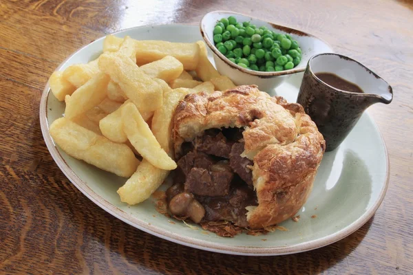 Steak and mushroom pie with chips and peas — Stock Photo, Image