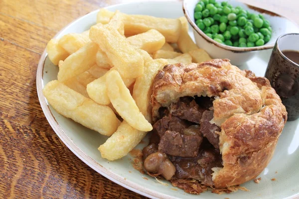 Steak and mushroom pie with chips and peas — Stock Photo, Image