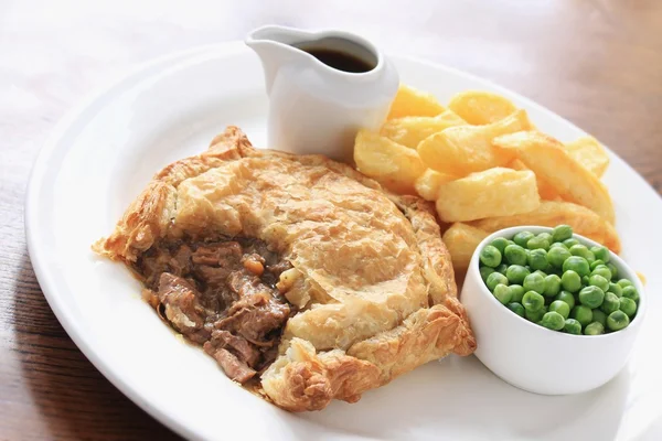 Traditional beef steak pie with chips and peas — Stock Photo, Image