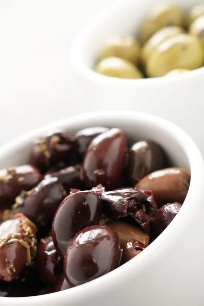 Green and black olives in white dishes — Stock Photo, Image