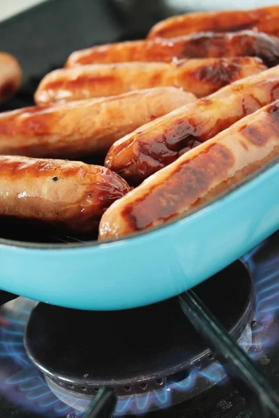 Sausages frying in pan — Stock Photo, Image