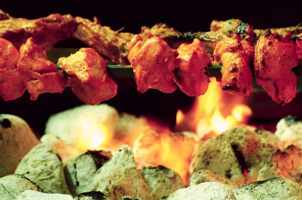Chicken Tikka on spit cooked over charcoal barbecue — Stock Photo, Image
