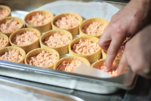 Chef préparant des tartelettes au saumon — Photo