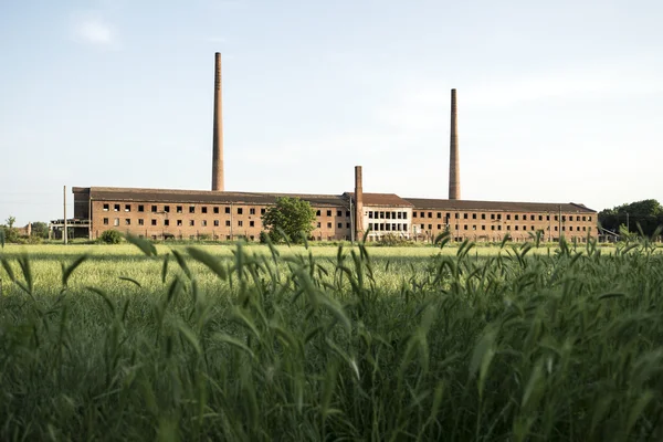 Фабрика на поле — стоковое фото