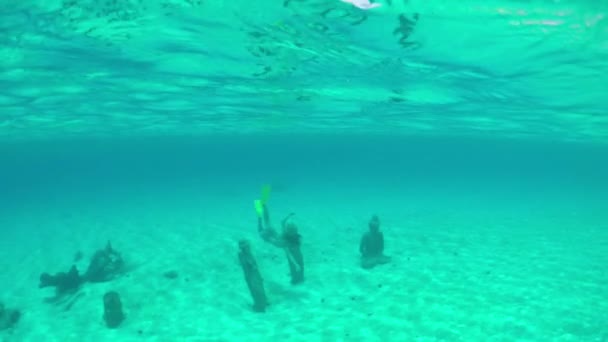 Медленное движение: женщина ныряет под водой, исследуя статуи на дне моря — стоковое видео