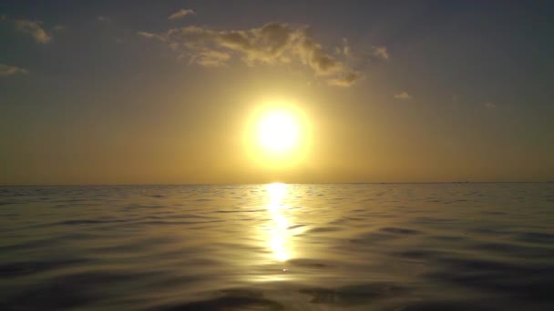 MOTION LENT : Incroyable coucher de soleil doré sur l'océan calme 