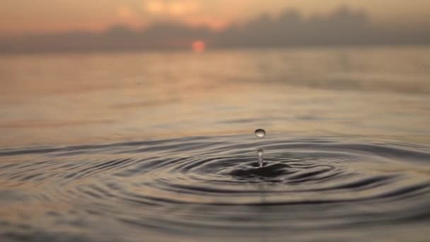 MOTION DE LENT FERMER : Une goutte d'eau tombe à la surface de l'océan — Video