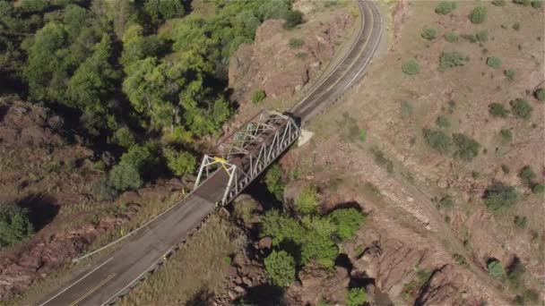 Landstraße und trockene Flussschluchtenbrücke in felsiger Wüste — Stockvideo