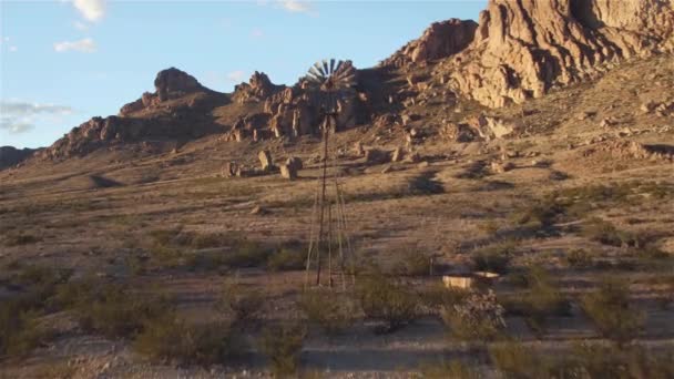 AEREO: sorvolando il mulino a vento d'epoca nel soleggiato deserto roccioso di montagna — Video Stock