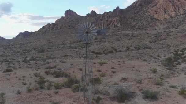 Antenn: stor vintage väderkvarn under vackra klippiga berg — Stockvideo