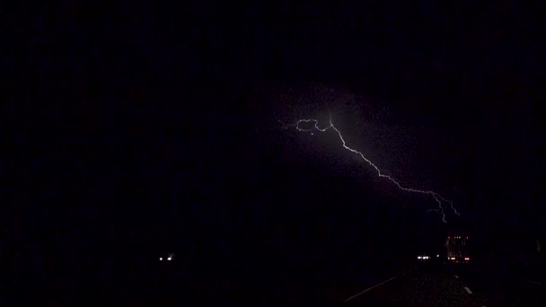 SLOW MOTION: Thunderstorm lightning bolt striking over highway traffic — Wideo stockowe