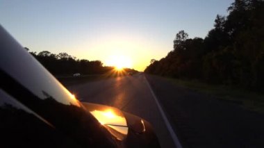 Ağır çekim: karanlık karayolu üzerinde altın yaz güneş doğarken kişisel Suv araba