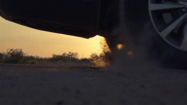 Auto startet und fährt schnell davon, Reifen drehen sich schnell und heben Sand und Staub auf — Stockvideo