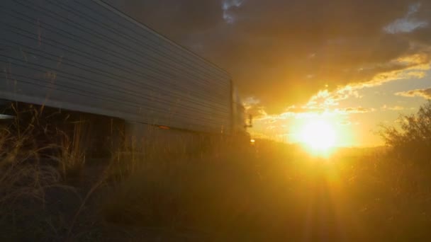 Vracht semi vrachtwagen versnellen op lege snelweg over gouden zon bij zonsondergang zomer — Stockvideo