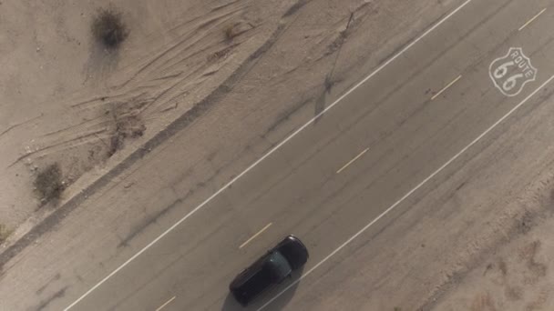 AERIAL: Coche SUV negro en viaje por carretera conduciendo a lo largo de la histórica Ruta 66 en Estados Unidos — Vídeo de stock