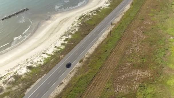 Antenne: Zwarte Suv auto rijden op platteland weg langs de baai van Mexico — Stockvideo