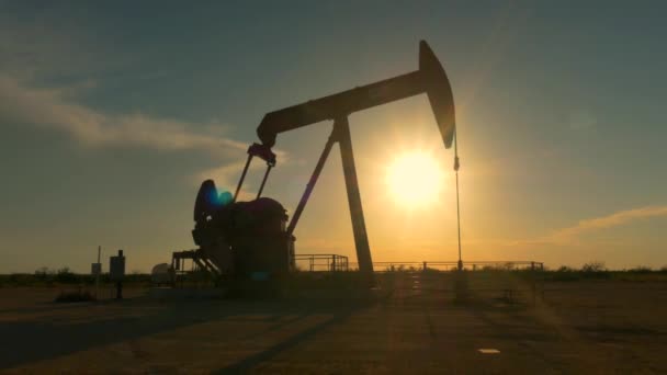 Piattaforma pompa jack industriale pompaggio di petrolio greggio sopra sole tramonto — Video Stock