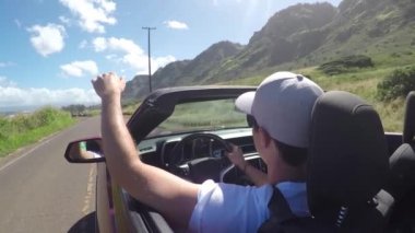 Closeup: Kırmızı cabrio adam kıyı yolu boyunca sürüş, rüzgar ile oynarken