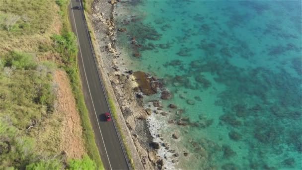 AERIAL: Vermelho conversível condução na bela estrada costeira na ilha vulcânica — Vídeo de Stock