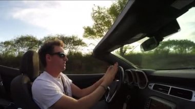 Close Up: Lüks cabriolet sürüş neşeli adam, müzik dinleme ve dans