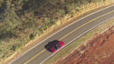 Aerial Close Up: Kırsal yol boyunca sürüş kırmızı cabrio araba çift