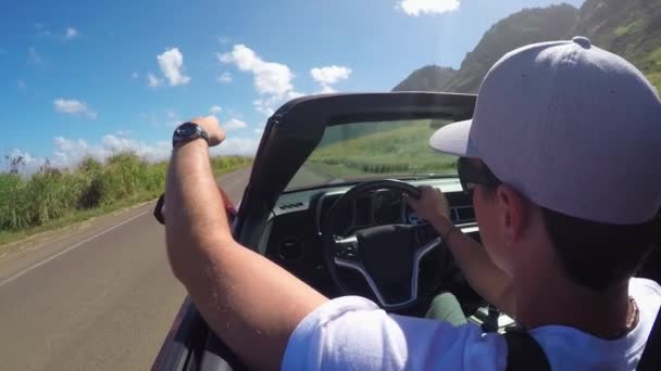 CERRADO: Hombre en convertible rojo de lujo conduciendo a lo largo de la playa en el soleado Hawaii — Vídeo de stock