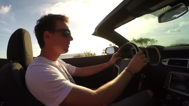 SLOW MOTION : Homme en cabriolet rouge conduisant le long de la route côtière sous le soleil d'Hawaï — Video