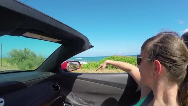 Movimiento lento: Mujer sonriente conduciendo a lo largo de la costa jugando con el viento en verano — Vídeos de Stock