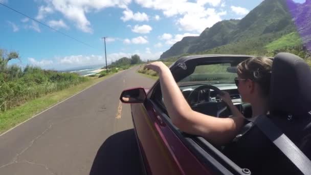 スローモーション:海岸沿いの道路を運転する夏休みに若い女性を笑顔 — ストック動画