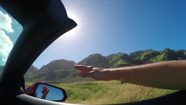 Zeitlupe: Arm vor Cabrio spielt mit Wind gegen sonnigen Himmel — Stockvideo