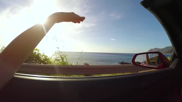 LOW MOTION: Dirigir ao longo da praia ao pôr-do-sol, acenando à mão no vento de verão — Vídeo de Stock