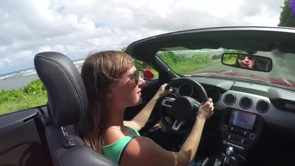 SLOW MOTION: Donna sorridente che guida su strada costiera in auto cabriolet rossa di lusso — Video Stock