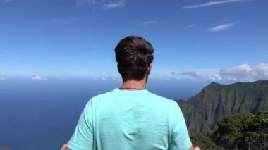 Yavaş Hareket: Dağın tepesindeki gururlu genç adam kollarını başarıyla esnetiyor