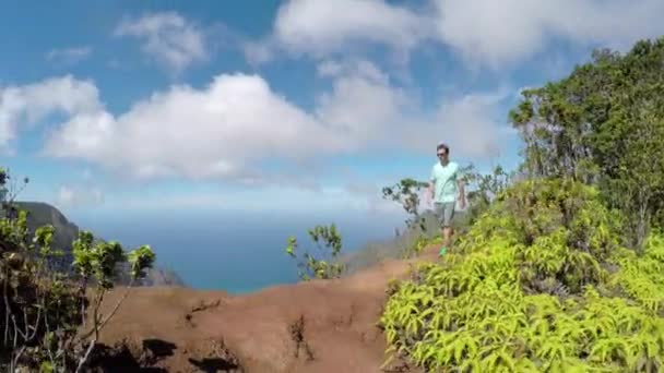 活跃的年轻人沿着高山山脊在郁郁葱葱的火山峡谷徒步旅行 — 图库视频影像