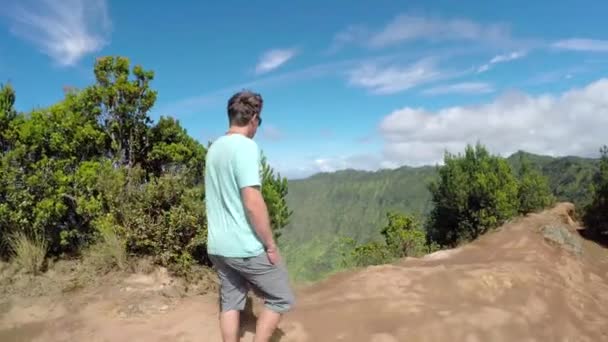 Aktiv ung man vandra längs höga berget åsen i grönskande vulkaniska canyon — Stockvideo