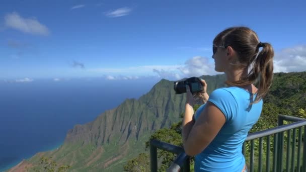 Närbild: ung kvinna tar bilder av fantastisk utsikt på toppen av berget — Stockvideo