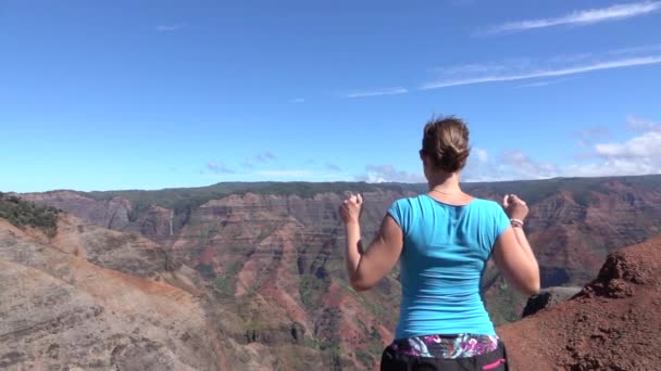 Lassú mozgás: Boldog fiatal nő raising karját büszkén hegy tetején — Stock videók