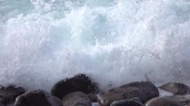 SLOW MOTION CLOSE UP: Ocean waves breaking and splashing into volcanic rocks