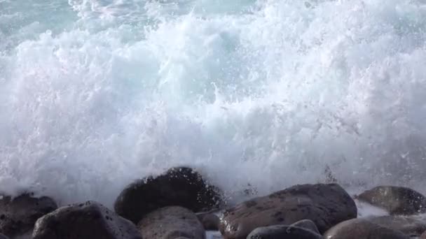 Zeitlupe aus nächster Nähe: Ozeanwellen brechen und spritzen in vulkanisches Gestein — Stockvideo