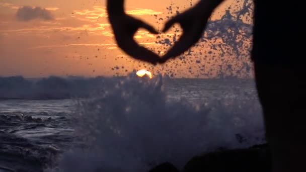 MOTION LENT : Jeune fille capturant beau ciel doré avec des mains en forme de coeur — Video