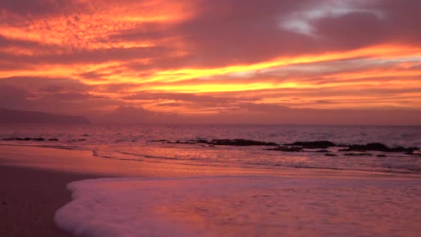 Slow motion närbild: eldig röd och orange solnedgång himmel på fantastiska sandstrand — Stockvideo